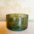 Load image into Gallery viewer, Green crystal sound bowl on a textured surface with a neutral background