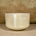 Load image into Gallery viewer, White crystal sound bowl on a textured surface with a neutral background