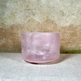 Load image into Gallery viewer, Pink crystal sound bowl on a textured surface with a neutral background
