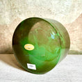Load image into Gallery viewer, Green crystal sound bowl with a label on a textured surface