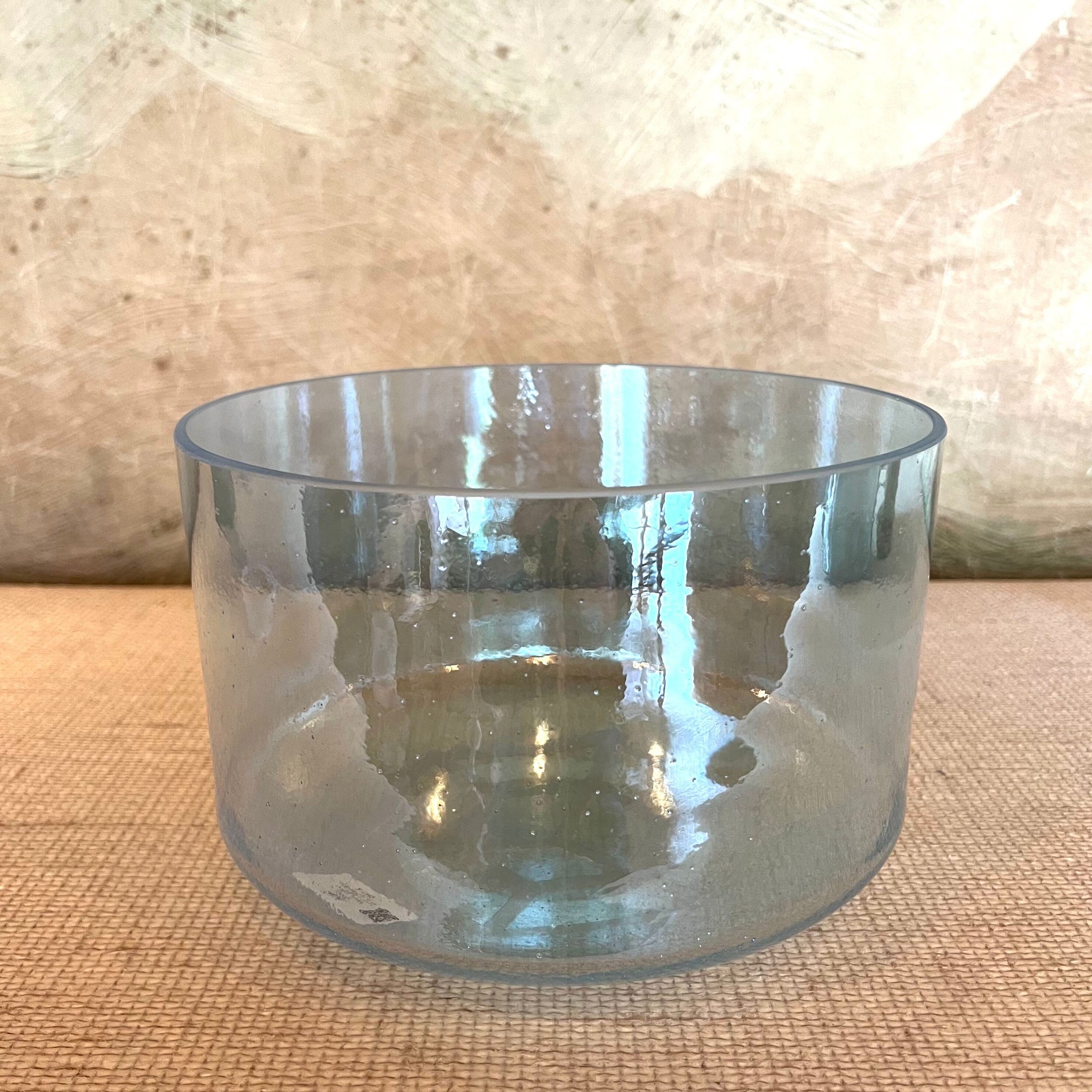 Clear crystal sound bowl on a textured surface