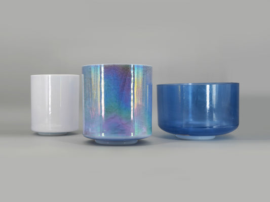 Three crystal sound bowl with reflective surfaces on a gray background