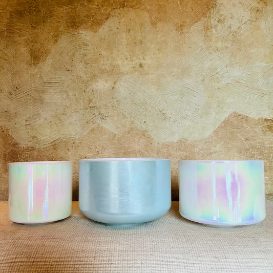 Three Crystal Sound Bowl with pastel color patterns on a textured surface.