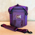 Load image into Gallery viewer, Purple crystal sound bowl carry case with a visible brand Crystal Tones logo on a beige surface
