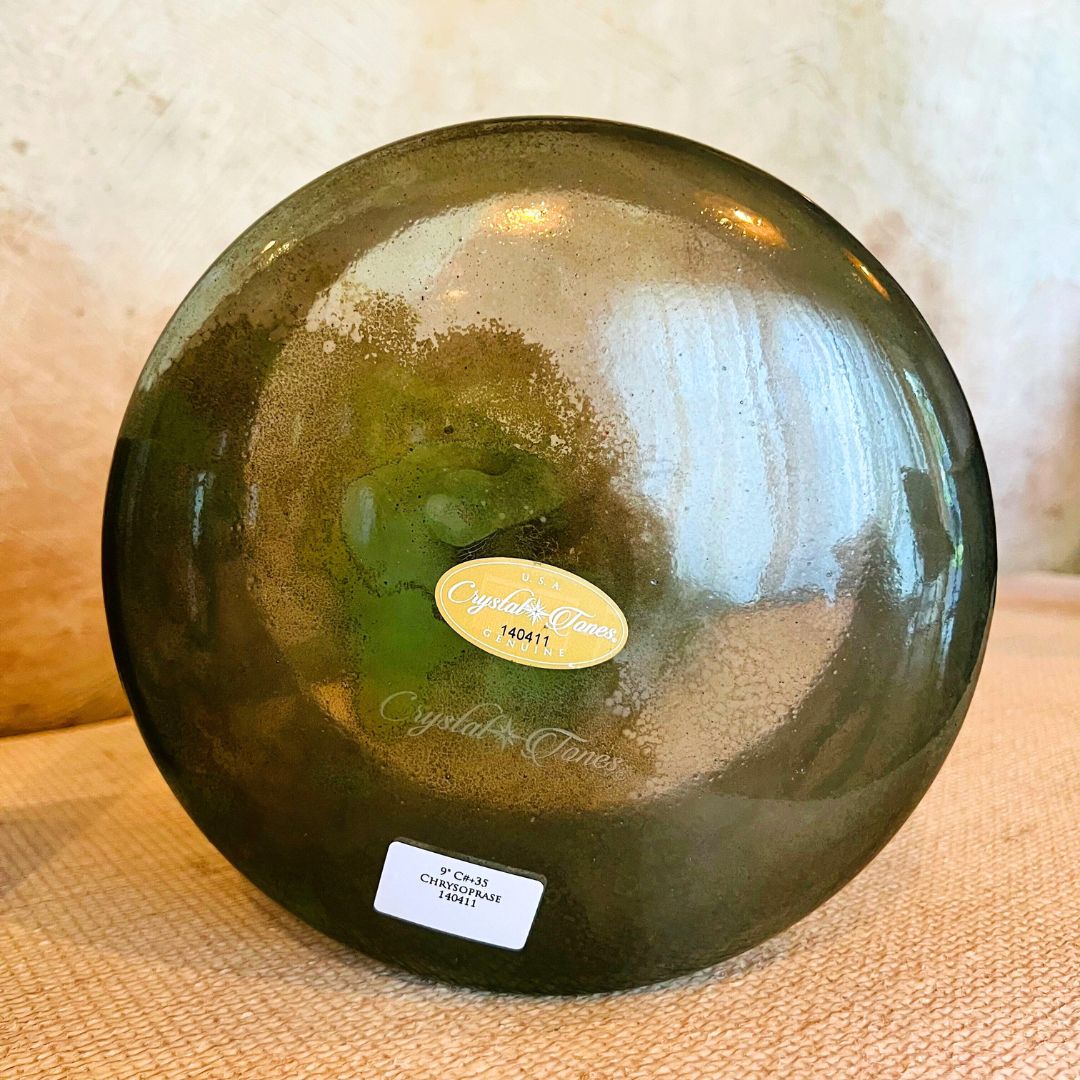 Green Crystal Sound Bowl with a Crystal Tones label on a textured surface