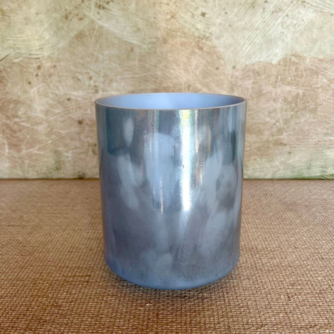 Blue crystal sound bowl on a textured surface with a wooden background