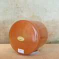 Load image into Gallery viewer, Round terracotta-colored crystal sound bowl with a visible Crystal Tones brand label on a textured surface.
