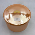 Load image into Gallery viewer, View of the base of an orange Crystal sound bowl with two lables 
