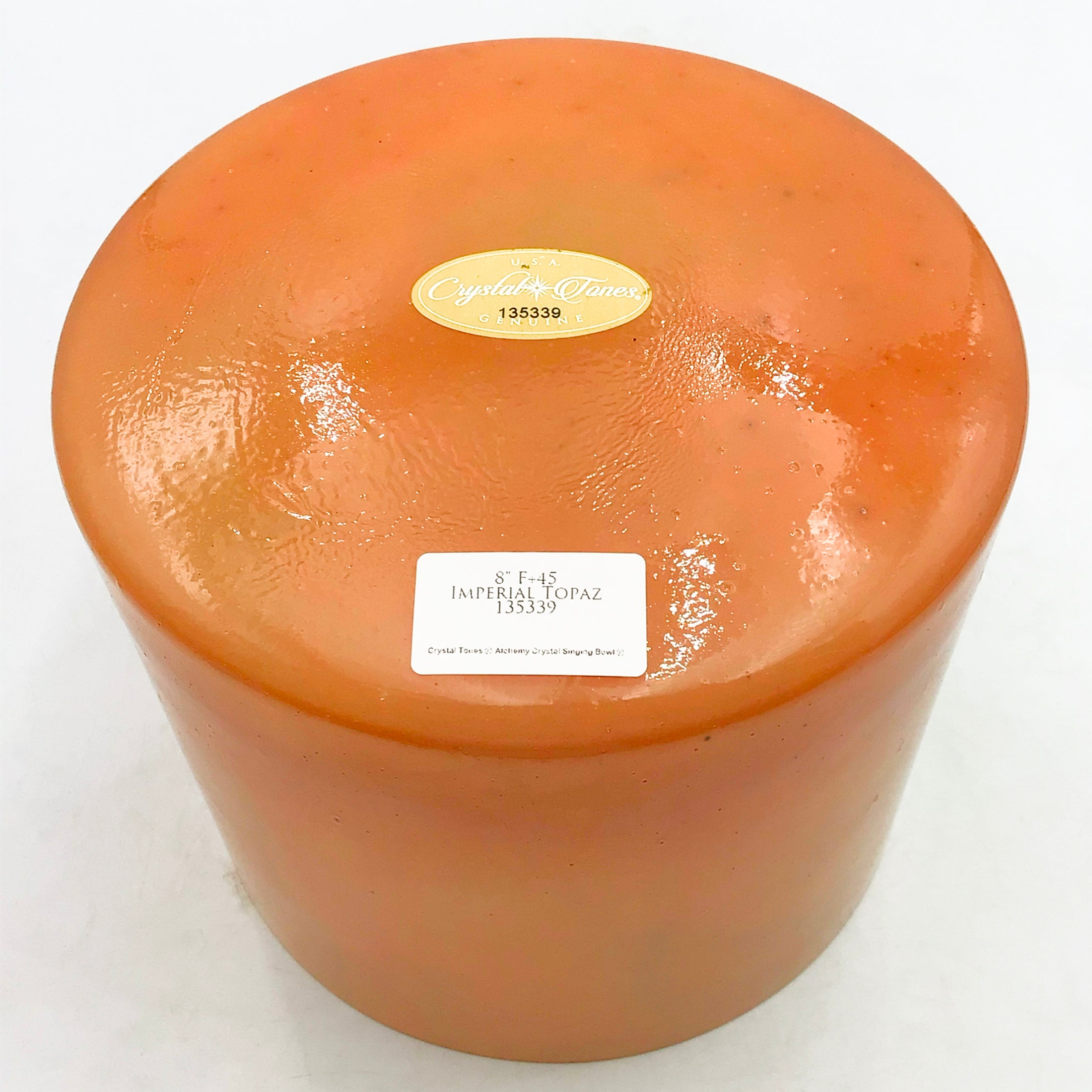 View of the base of a crystal sound bowl with labels on a white background