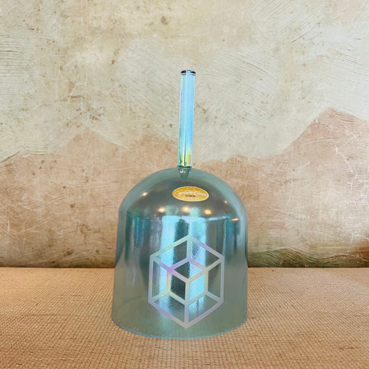 Metallic blue crystal sound bowl with geometric design on a textured surface