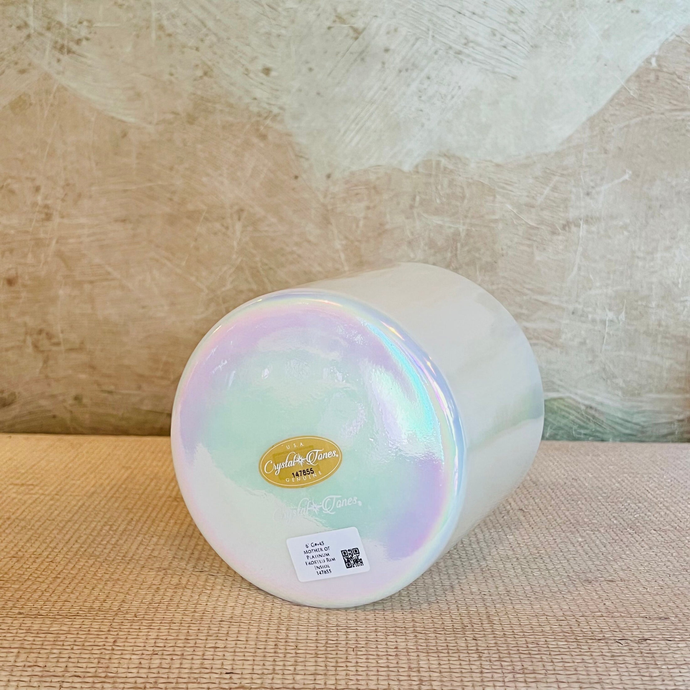 Iridescent Crystal Sound Bowl with a Crystal Tones bowl on a textured surface with a neutral background