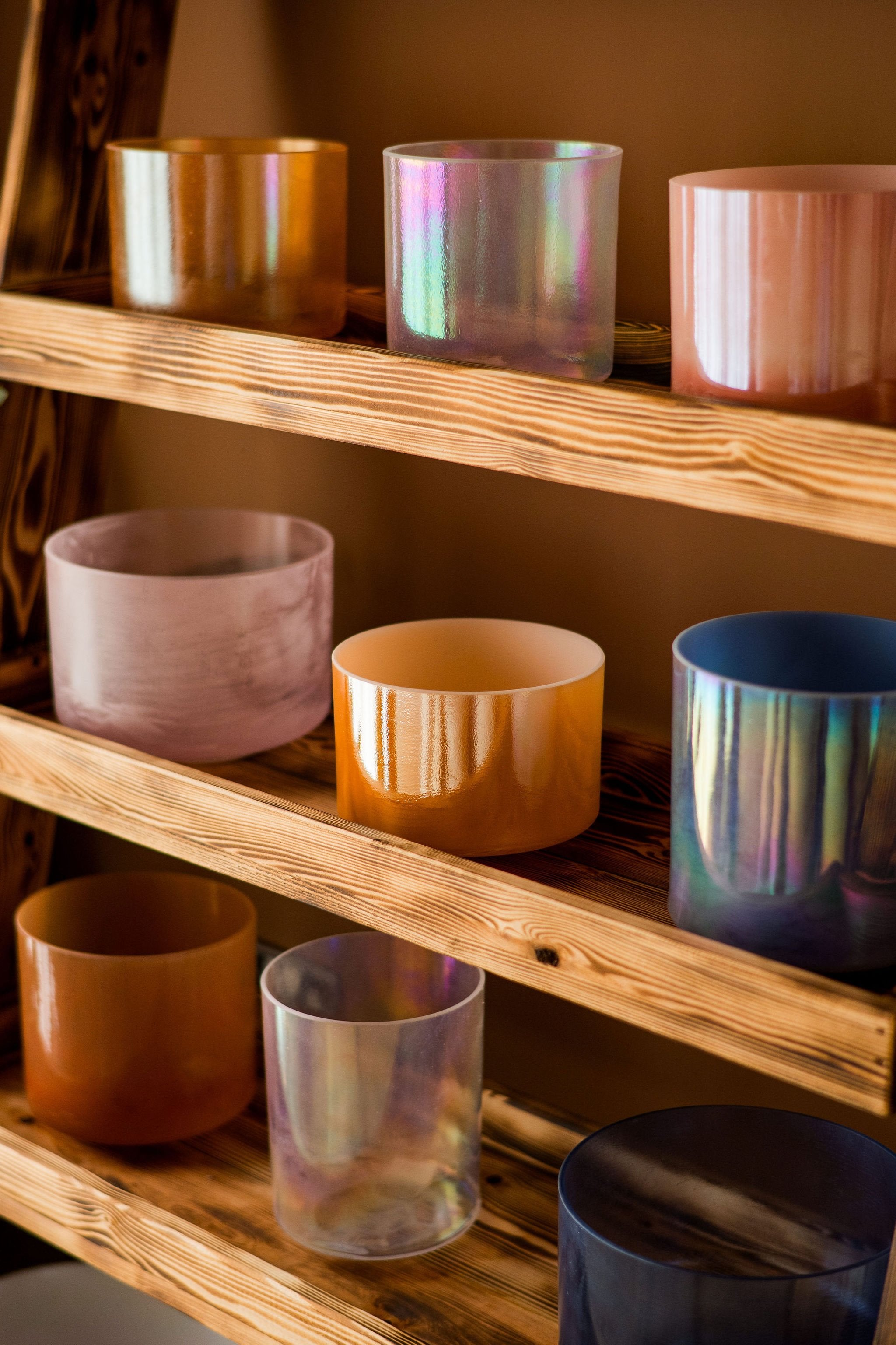 Close up of crystal sound bowls on a wooden shelf