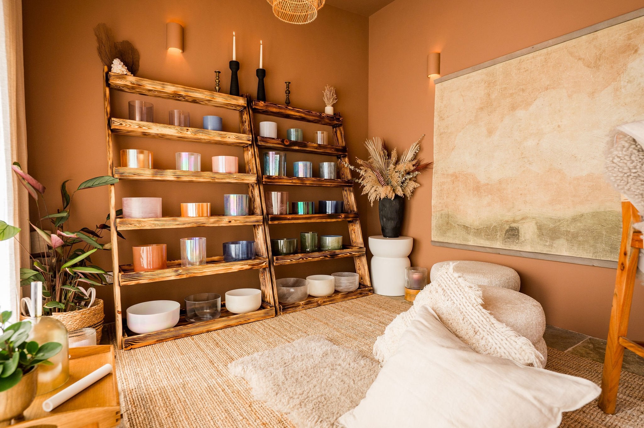 A cozy room with wooden shelves, a rug, and decorative items, part of the crystal sound temple.
