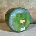Load image into Gallery viewer, Green crystal sound bowl with a gold Crystal Tones label on a textured surface

