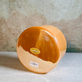 Load image into Gallery viewer, Round orange crystal sound bowl with a label on a textured surface
