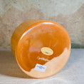 Load image into Gallery viewer, Round orange crystal sound bowl with a crystal tones label on a textured surface
