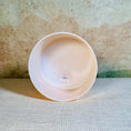 Load image into Gallery viewer, White crystal sound bowl with a label on a textured surface
