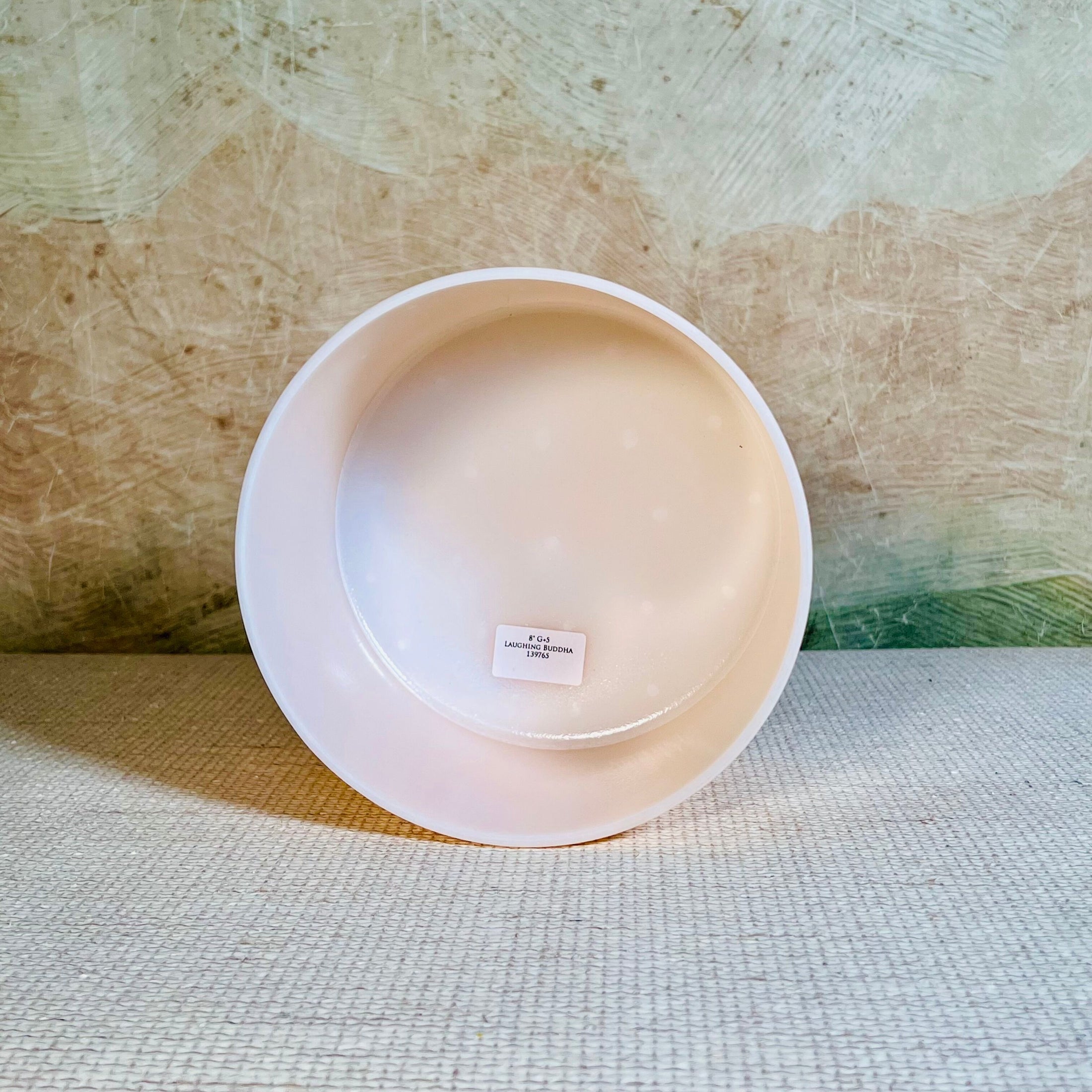 White crystal sound bowl with a label on a textured surface