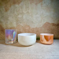 Load image into Gallery viewer, Three crystal sound bowls with different finishes on a textured surface.
