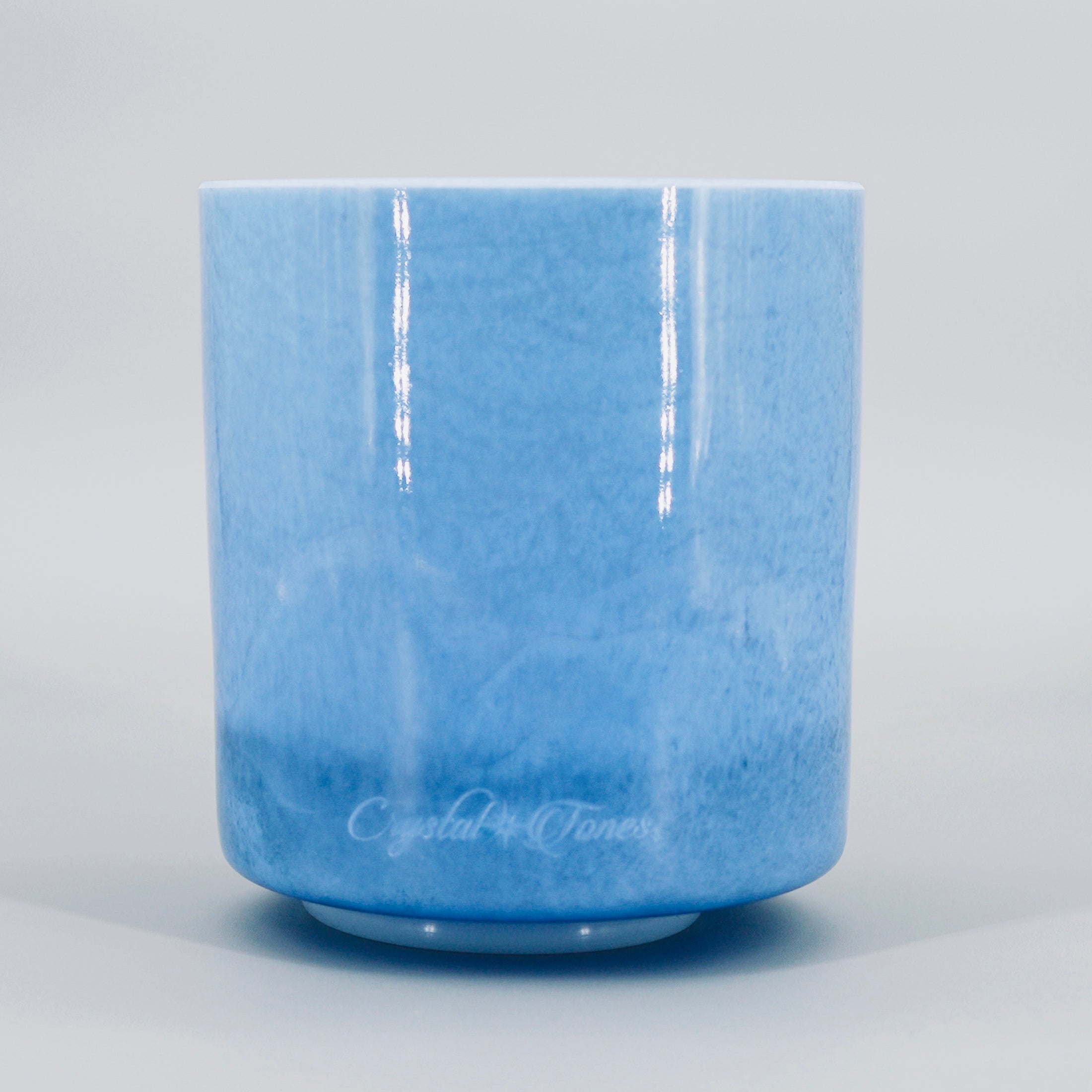 blue crystal sound bowl with Crystal Tones logo on the bowl photographed on a grey backround
