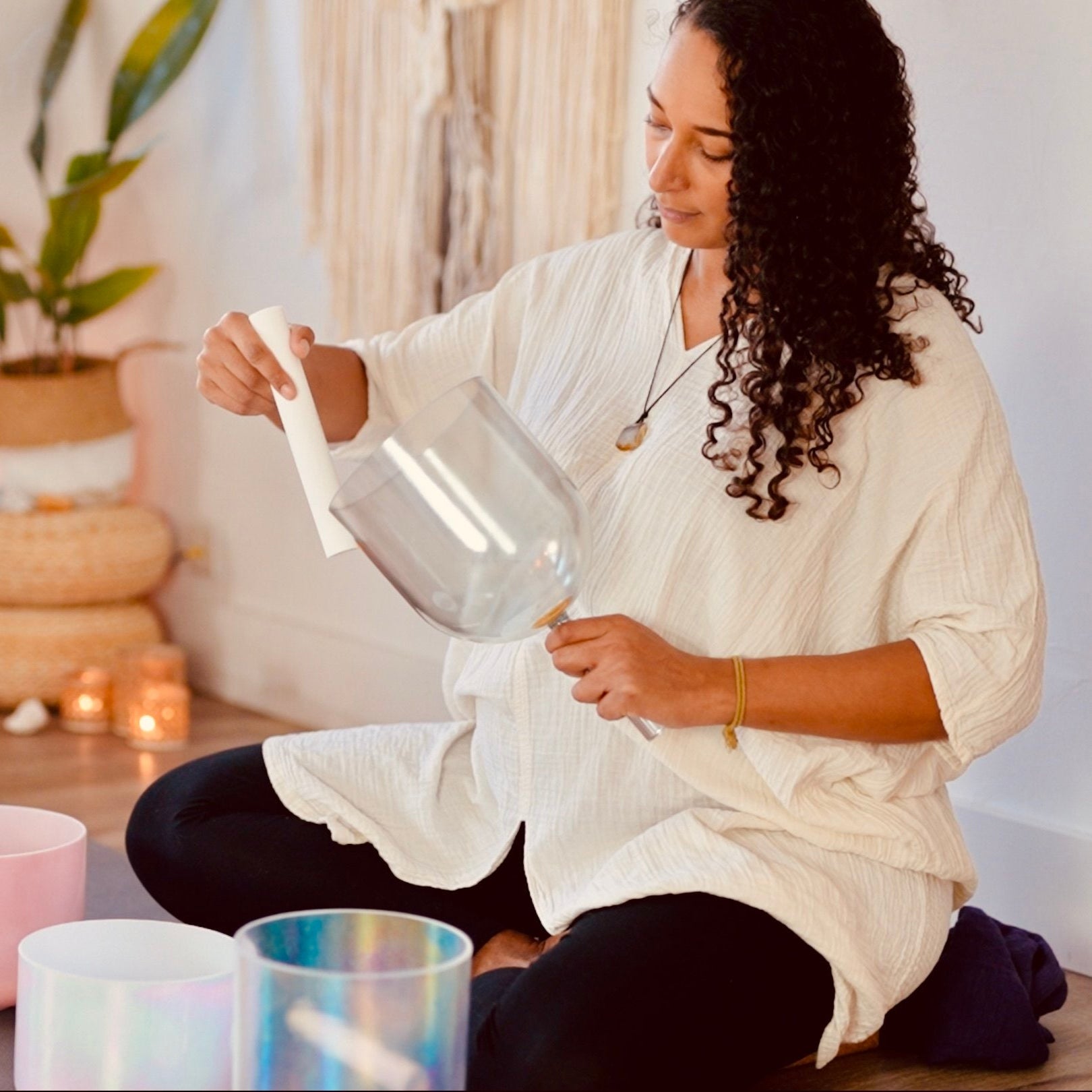 Woman - Casey - sitting on the floor with a clear crystal sound bowl in a sound temple