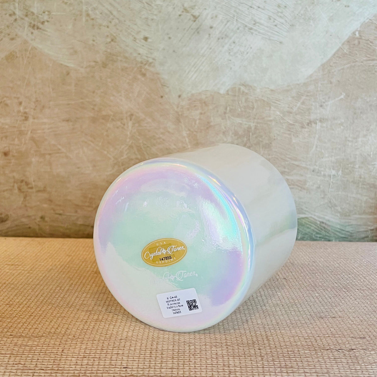 Iridescent Crystal Sound Bowl with a Crystal Tones bowl on a textured surface with a neutral background