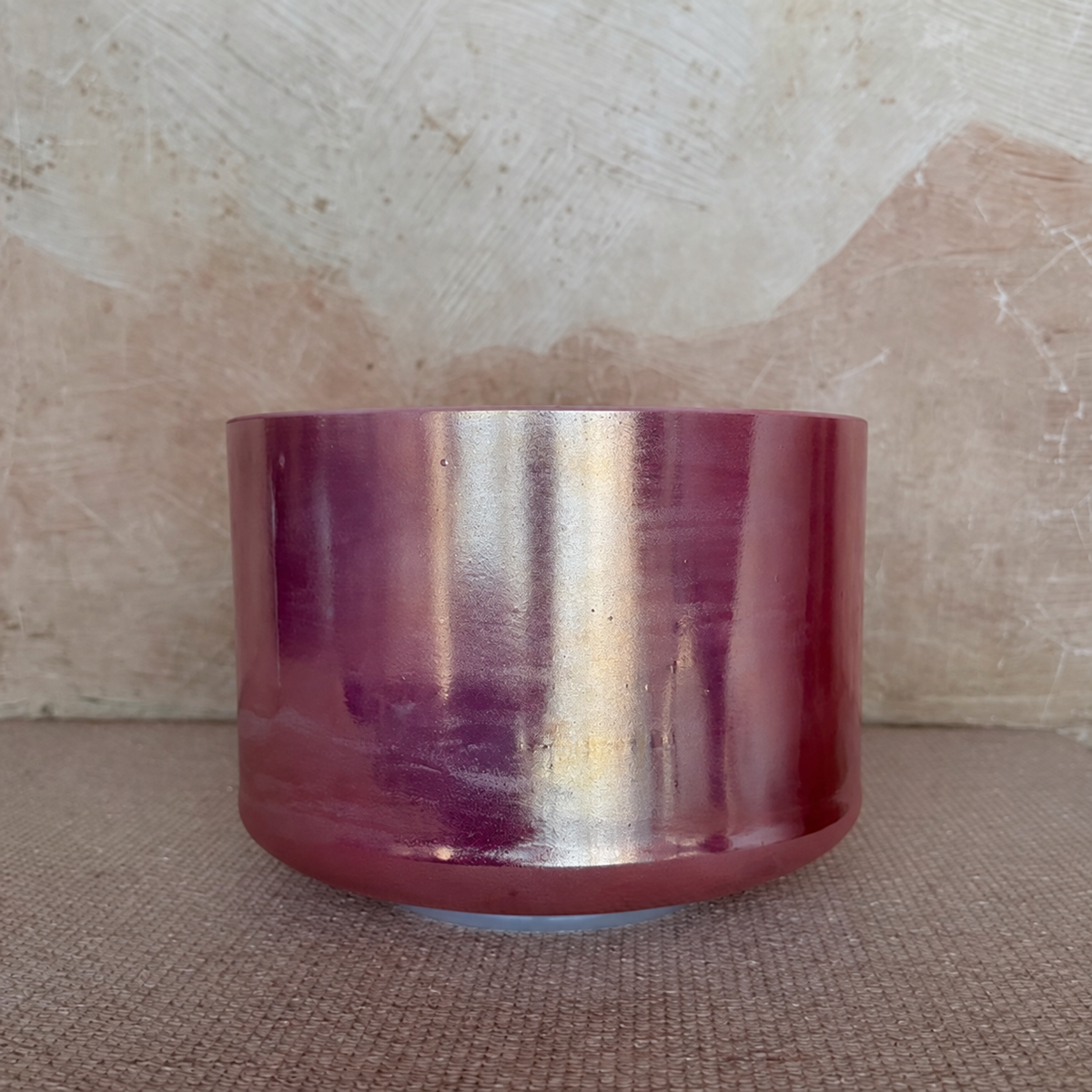Rose Quartz Palladium singing bowl with silver and gold-toned reflections across its pink exterior.