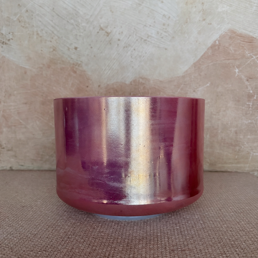 Rose Quartz Palladium singing bowl with silver and gold-toned reflections across its pink exterior.